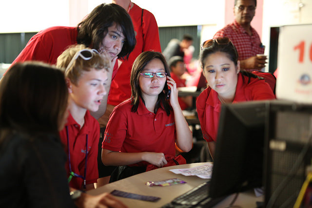photo of students working collaboratively on a computer look at the screen