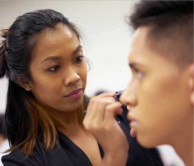 Cosmetology student applying makeup.